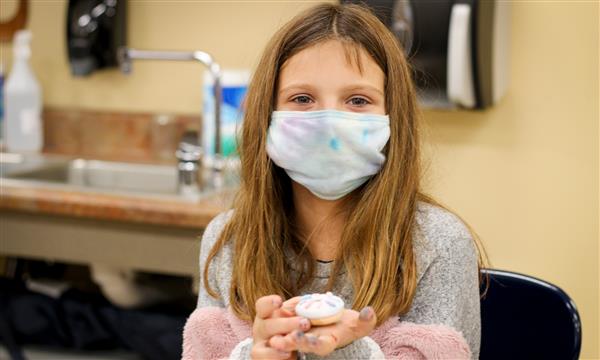 Girl holds up food model made of clay